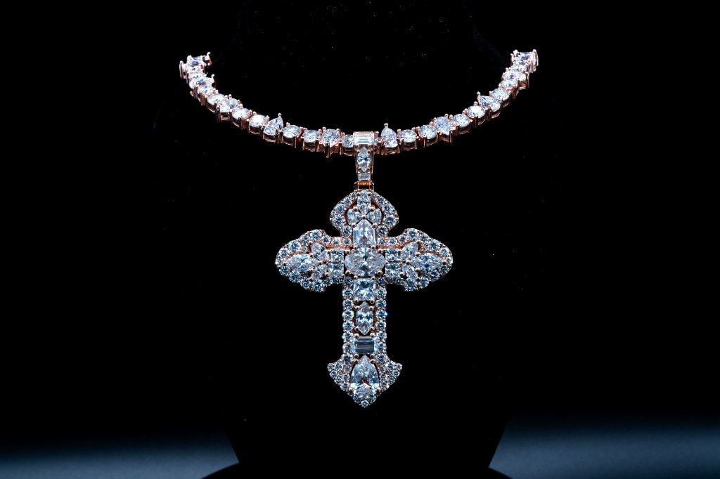 Ornate diamond cross pendant on a full diamond chain, rose gold, on black